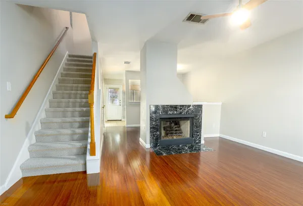 a view of a livingroom with wooden floor and a fireplace