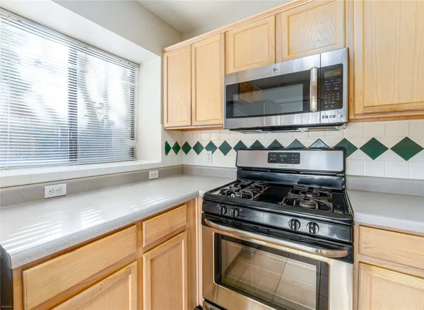 a kitchen with stainless steel appliances granite countertop white cabinets and a stove top oven