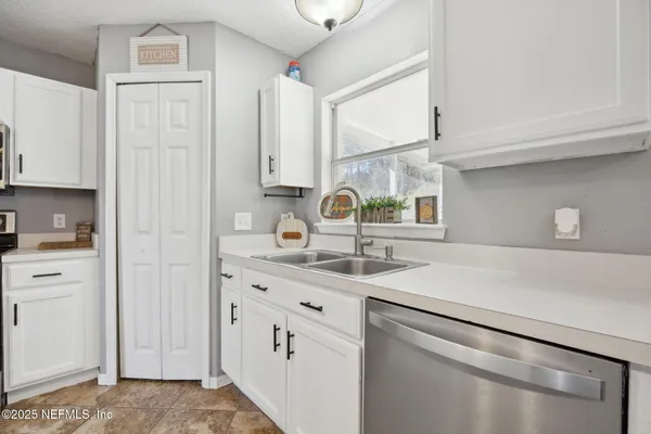 a kitchen with stainless steel appliances granite countertop white cabinets and black stove top oven with granite countertops