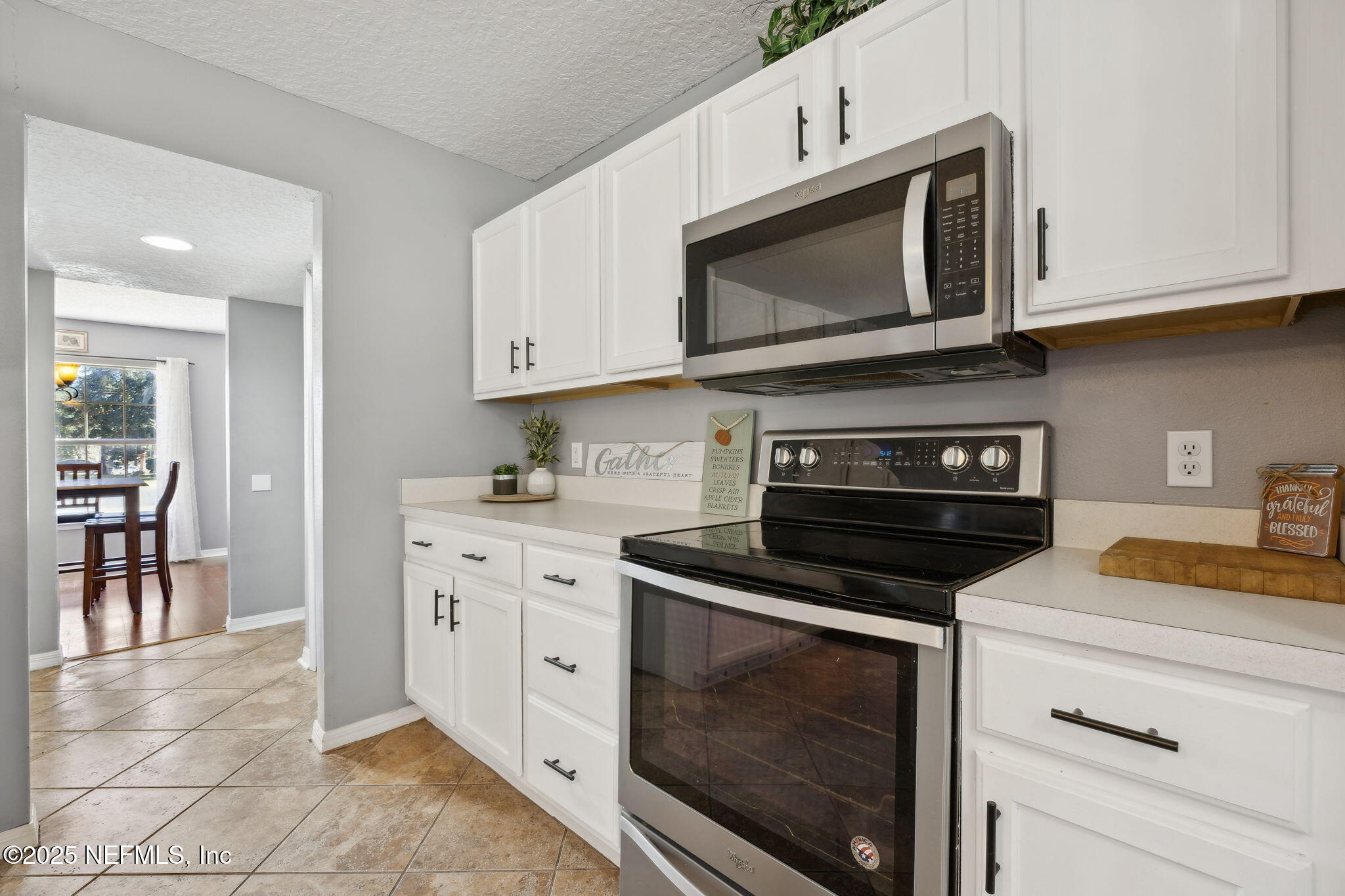 87002 Kip Lane Yulee, FL 32097 - Photo 18 of 54 a kitchen with stainless steel appliances granite countertop white cabinets and black stove top oven with granite countertops