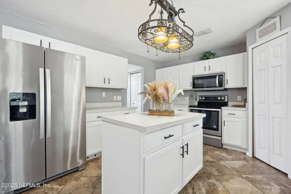 a kitchen with stainless steel appliances a refrigerator stove and microwave