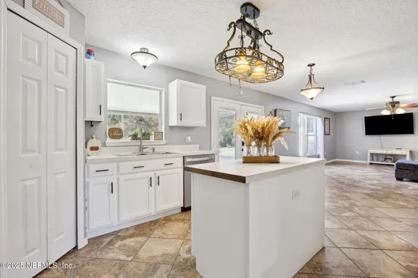 a kitchen with kitchen island granite countertop a sink and a stove top oven