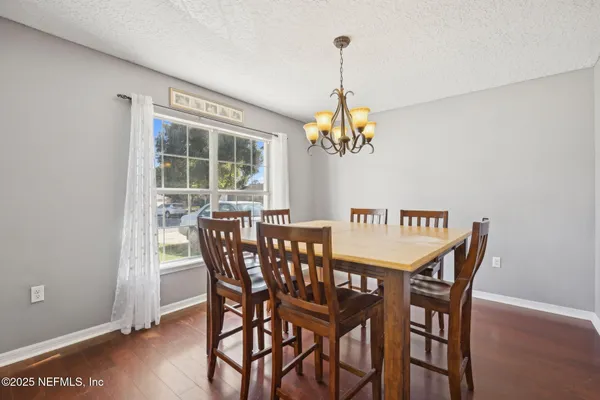 a view of a dining room with furniture wooden floor and chandelier