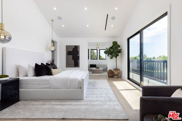 a bedroom with a large bed and a couch next to a window