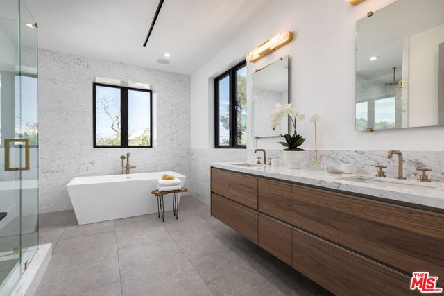 a bathroom with a double vanity sink mirror and bathtub