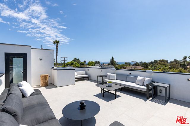 a view of a terrace with couches and city view