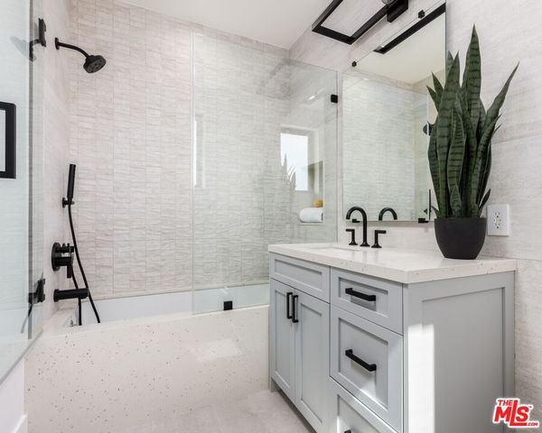 a bathroom with a sink a mirror and a potted plant
