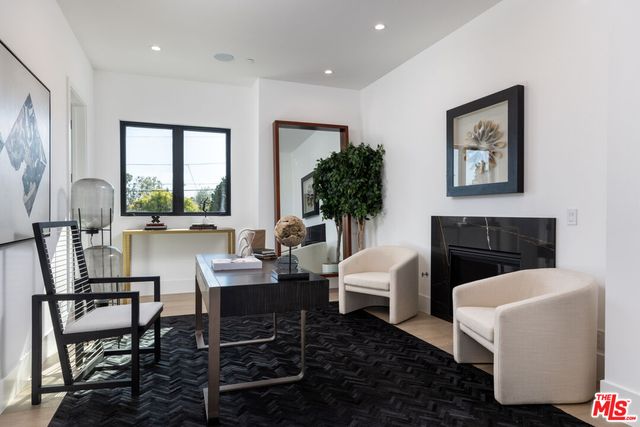 a living room with furniture a fireplace and a potted plant