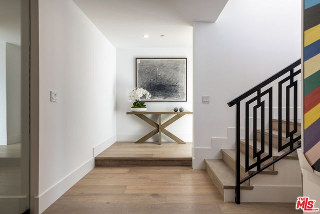 a view of a hallway with wooden floor and stairs
