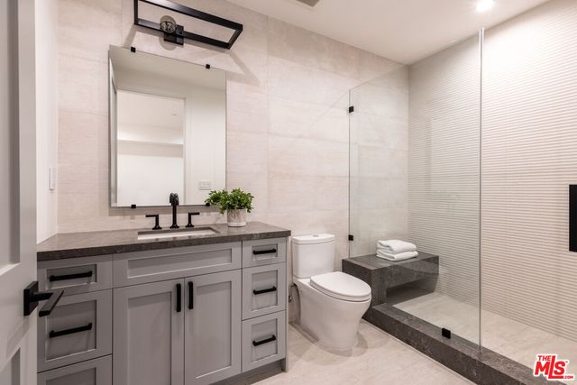 a bathroom with a granite countertop sink a toilet and a mirror