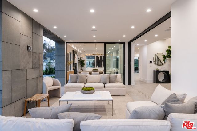 a living room with furniture and a floor to ceiling window