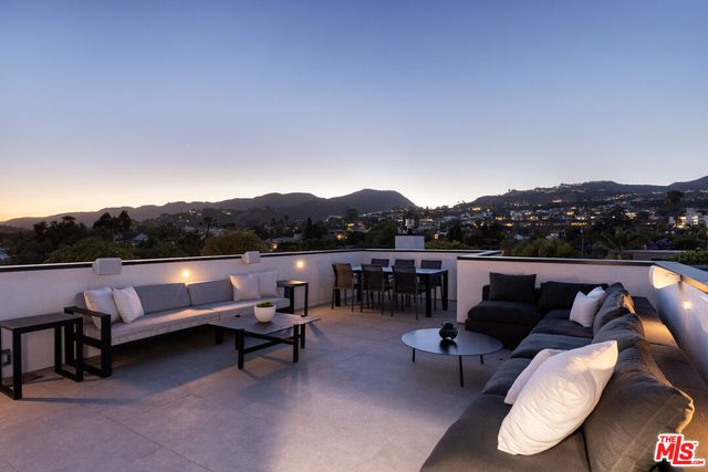 a terrace with outdoor seating and trees