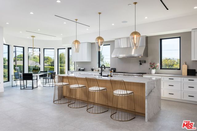 a large kitchen with kitchen island a large island in it