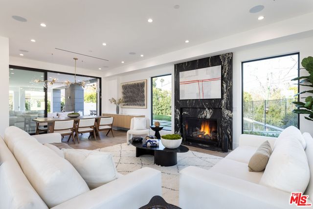 a living room with furniture large window and a fireplace