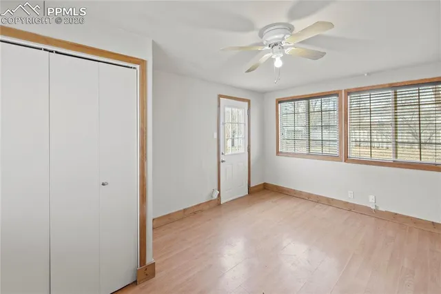 an empty room with fan and windows
