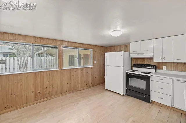 a kitchen with white cabinets and white appliances