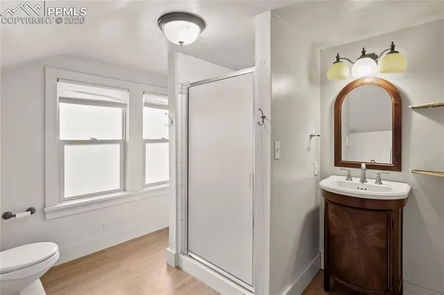 a en suite bathroom with a granite countertop toilet sink and mirror