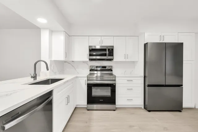 a kitchen with stainless steel appliances granite countertop a refrigerator stove and sink