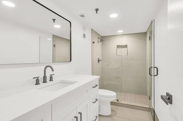 a bathroom with a sink a toilet and shower