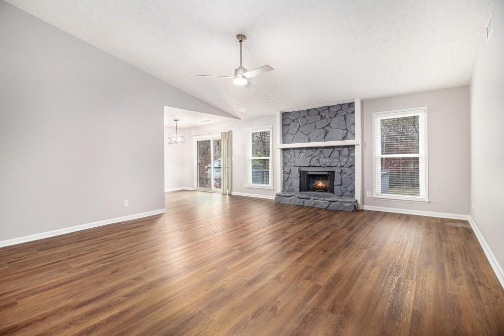 5524 Dorsett Shoals Road Douglasville, GA 30135 - Photo 2 of 33 an empty room with wooden floor fireplace and windows