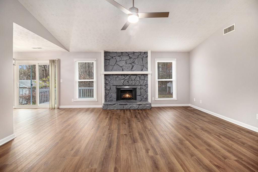 5524 Dorsett Shoals Road Douglasville, GA 30135 - Photo 3 of 33 a view of an empty room with wooden floor fireplace and a window