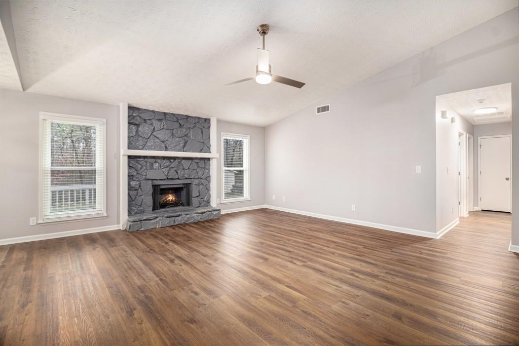 5524 Dorsett Shoals Road Douglasville, GA 30135 - Photo 4 of 33 a view of an empty room with wooden floor fireplace and a window