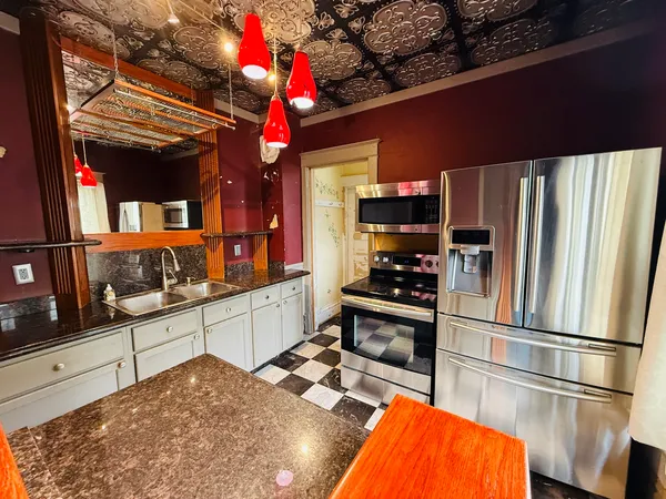 a kitchen with stainless steel appliances kitchen island granite countertop a refrigerator and a stove top oven