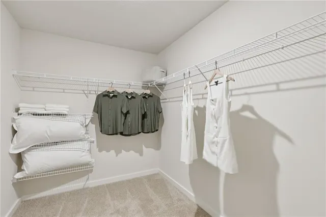a view of walk in closet with clothes and shoes