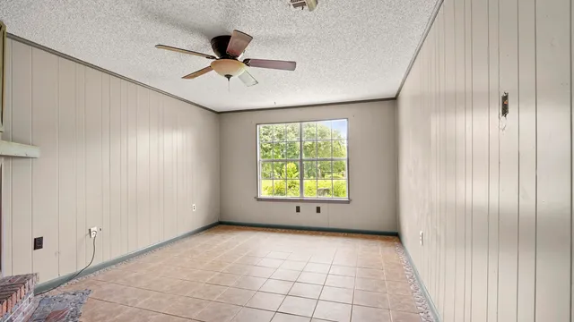 a view of an empty room with a fireplace and a window