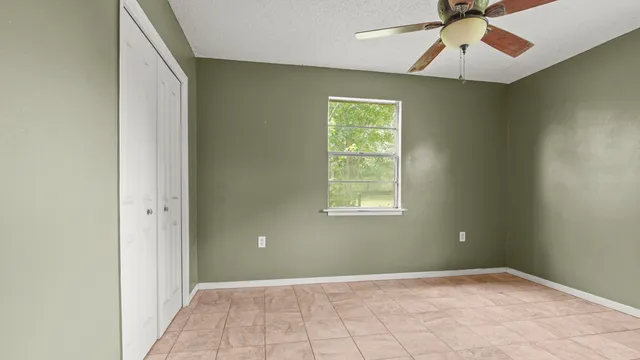 an empty room with windows and closet