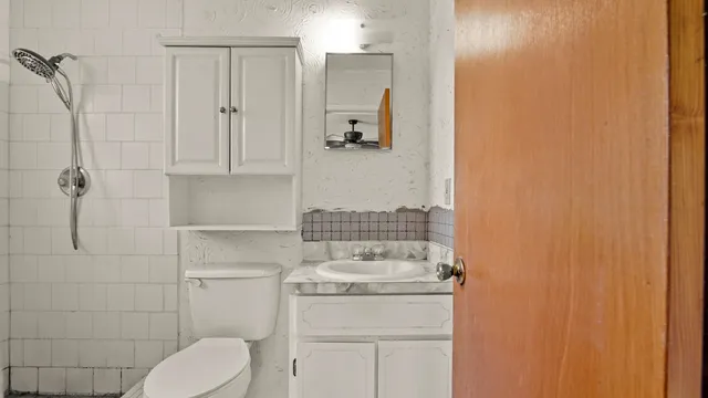 a bathroom with a toilet and a shower