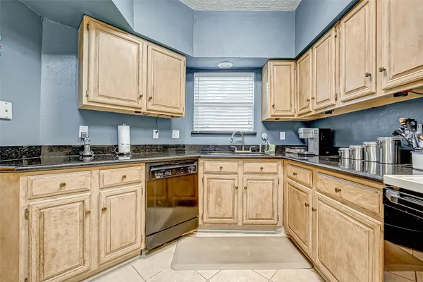 a kitchen with granite countertop white cabinets stainless steel appliances and sink