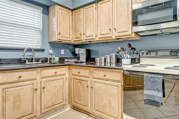 a kitchen with granite countertop white cabinets stainless steel appliances and a sink