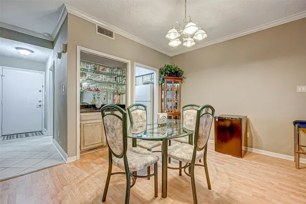 a view of a dining room with furniture a chandelier and wooden floor