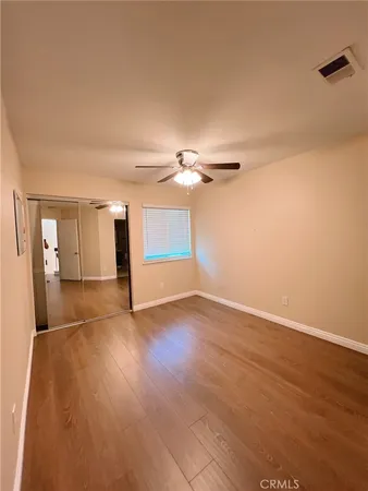 a view of a livingroom with wooden floor and a ceiling fan
