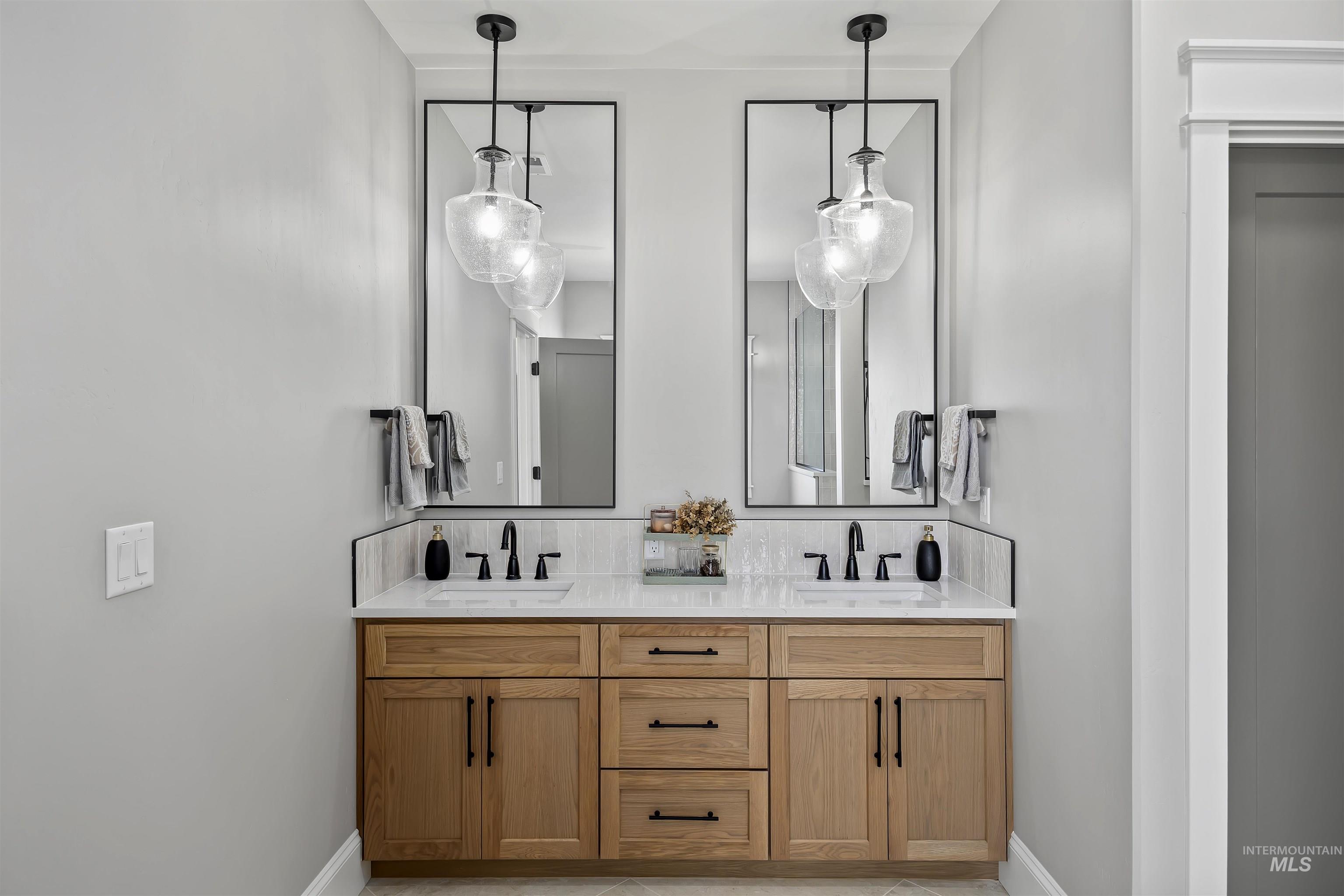 378 West 100 South Rupert, ID 83350 - Photo 24 of 50 Dual vanity featuring a light wood-finish cabinet with black hardware, white countertop, and matching rectangular sinks