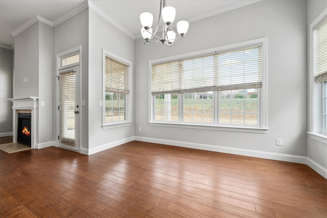 102 Ripplestone Way Anderson, SC 29621 - Photo 13 of 39 Hardwood floors and a cozy fireplace define this open dining area, perfect for entertaining.