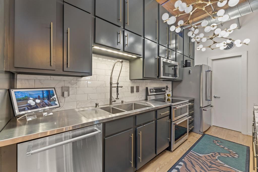 509 Elm Street, Unit 601 Dallas, TX 75202 - Photo 13 of 37 a kitchen with stainless steel appliances granite countertop a sink stove and refrigerator
