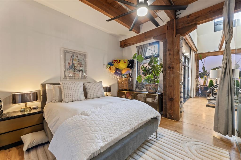 509 Elm Street, Unit 601 Dallas, TX 75202 - Photo 24 of 37 a bedroom with a large bed and a chandelier