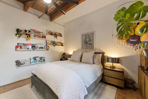 a bedroom with a bed and a painting on the wall