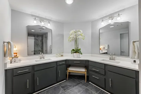 a en suite bathroom with a double vanity sink and a mirror