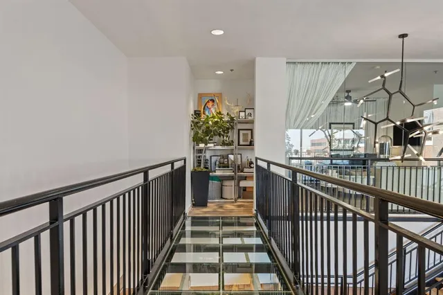 a view of a hallway with wooden floor and stairs