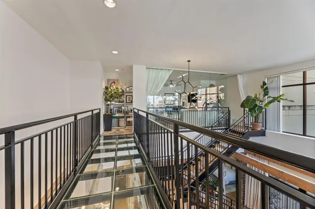 a view of a hallway with wooden floor and chandelier