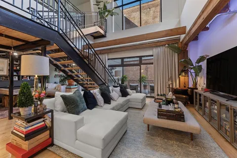 a living room with furniture a flat screen tv and couches