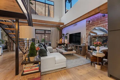 a living room with furniture a flat screen tv and a floor to ceiling window