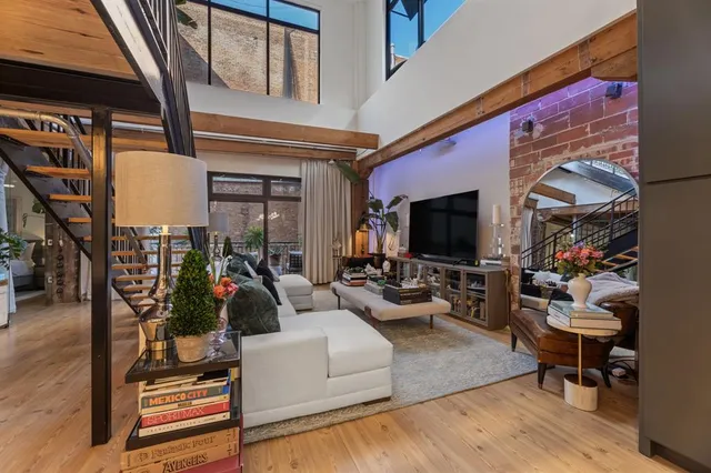 a living room with furniture a flat screen tv and a floor to ceiling window
