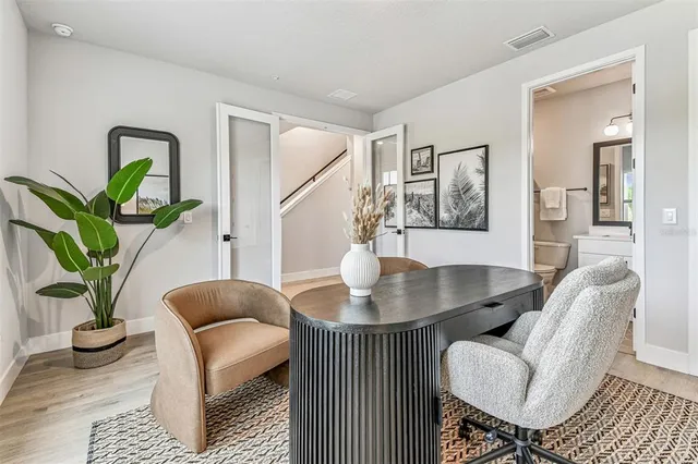 a kitchen with stainless steel appliances kitchen island granite countertop a stove a sink a oven a dining table and chairs with wooden floor