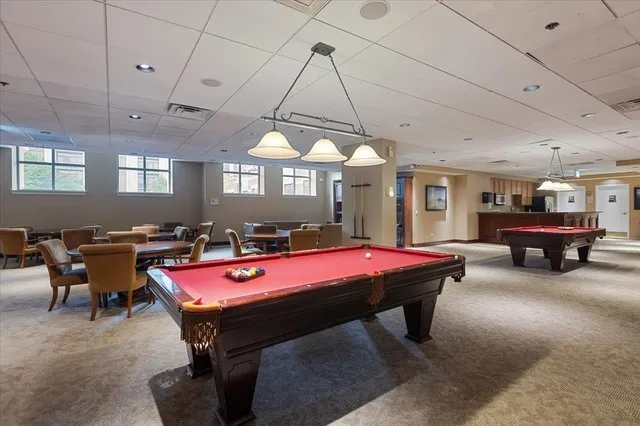 a room with furniture pool table and windows