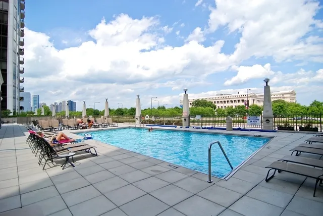 a swimming pool with outdoor seating and city view