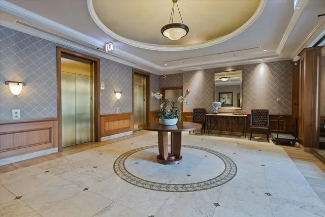 a lobby with furniture and a chandelier
